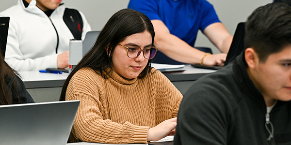 Female student in class with a laptop.